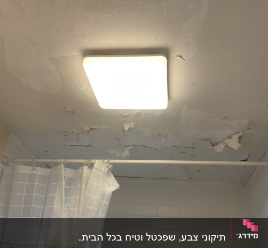 תקרה מתקלפת עם צבע מתקלף ליד מנורה